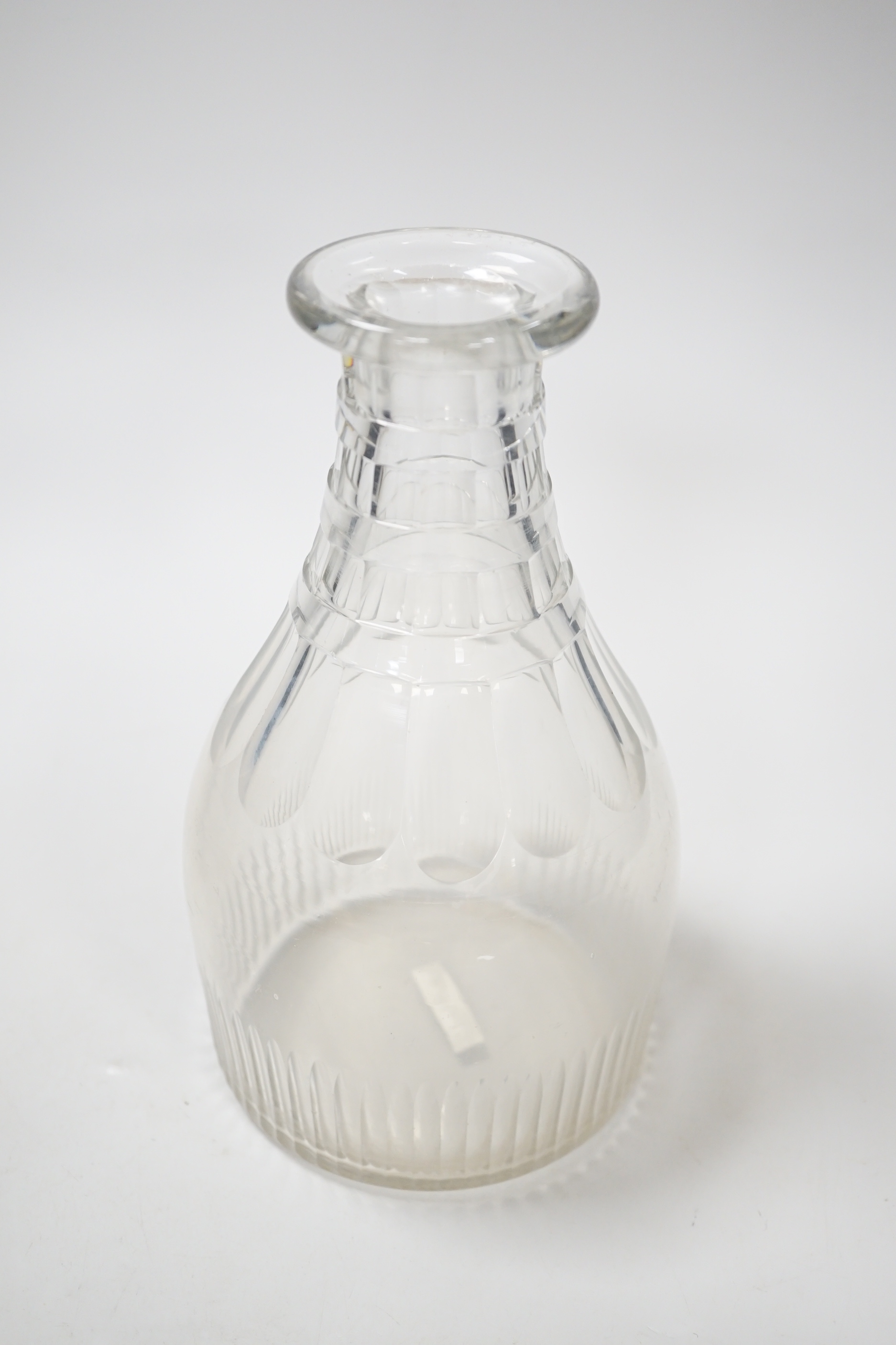 A rare English lead crystal Georgian carafe, c.1810-30, three rows of square cut facets replace earlier rings around neck followed by rounded facets and basal flutes, the base with ground and polished pontil, 22cm high